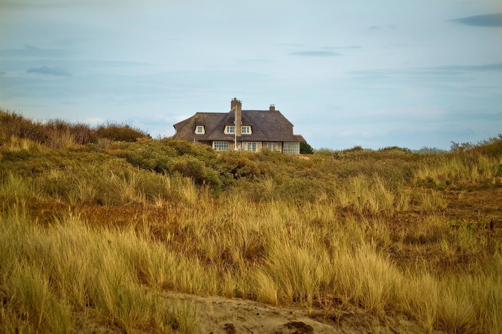farm house with beach grasses and sand in the foreground